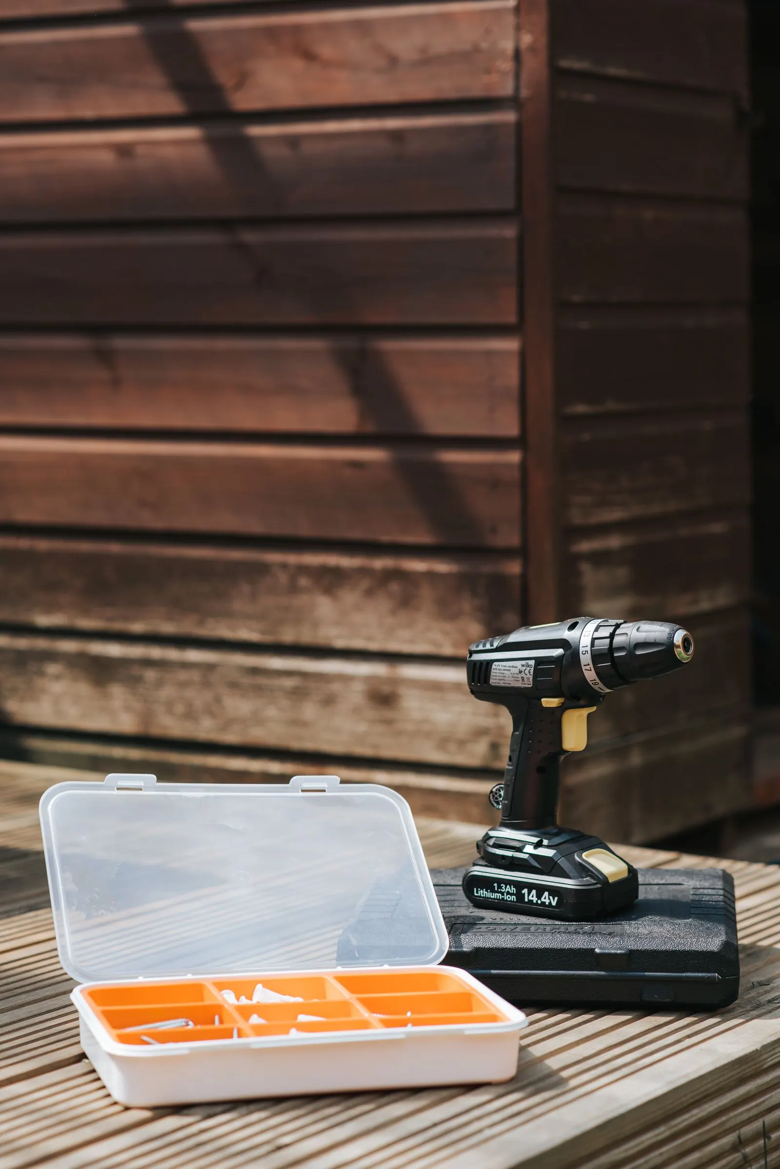 Cordless drill and bit set on wooden decking for a carpentry job