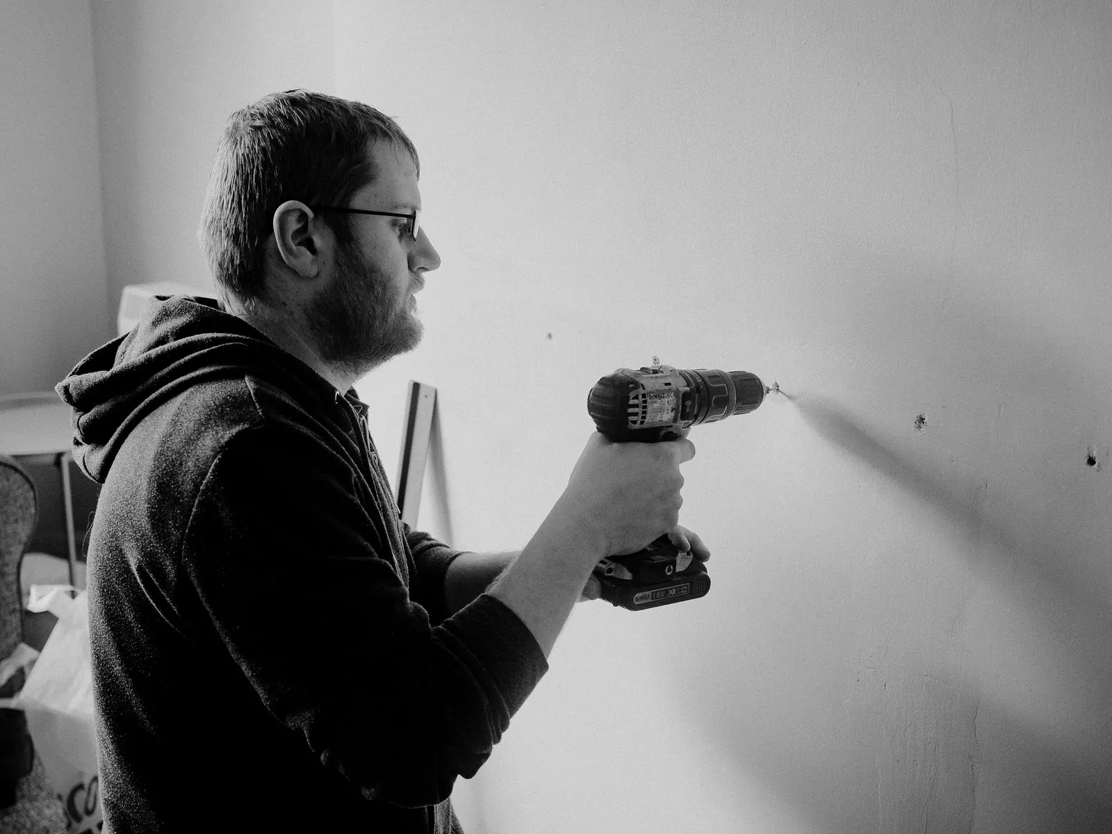 Man drilling into a wall to mount a bracket