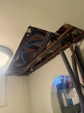 Ceiling opened up to expose joists and ductwork for a repair
