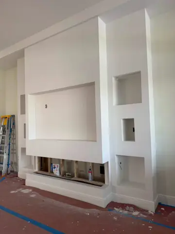 Custom built-in media wall with shelving framed and finished in drywall