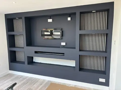 Custom dark built-in media wall with slatted panels