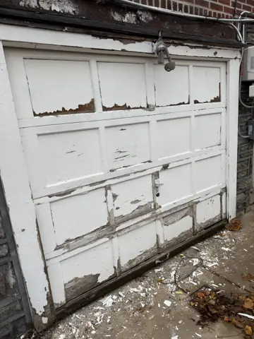 Damaged old garage door before replacement