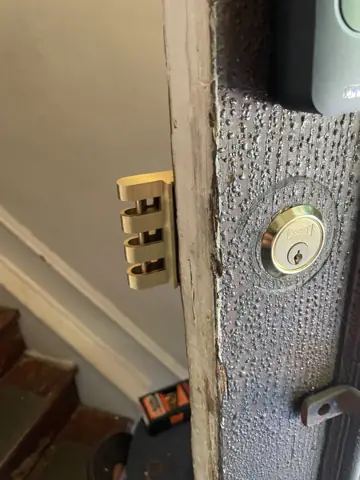 Door jamb with a new deadbolt strike and latch hardware installed