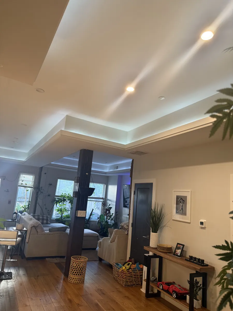 Finished open living room with a tray ceiling and hardwood floors
