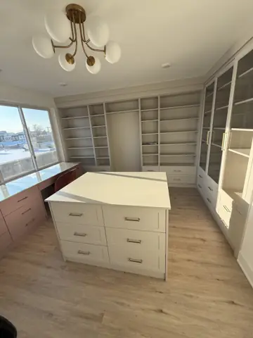 Finished room with built-in shelving and a center island