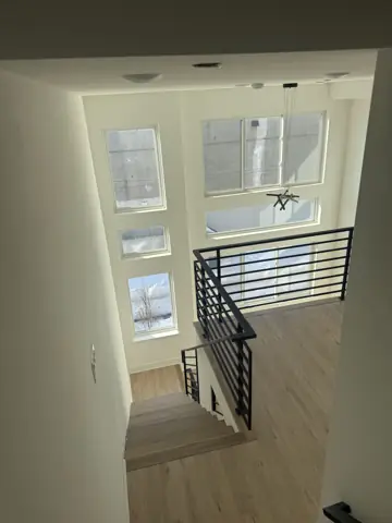 Finished stairwell with a modern black metal railing and tall windows