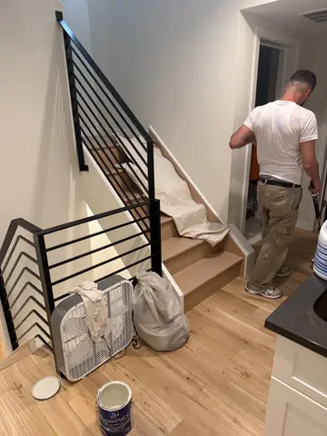 Finishing work in a stairwell with a black metal railing