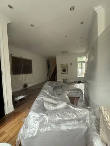 Furniture covered in plastic before drywall sanding