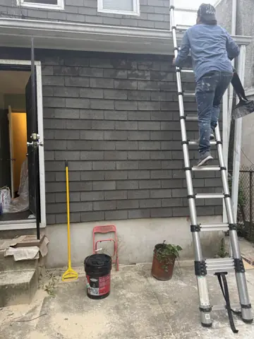 Ladder on a rowhome's exterior steps for siding and facade work