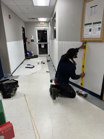 Measuring and installing wall trim in a commercial hallway