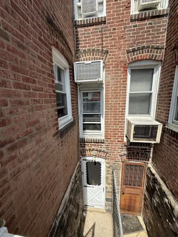 Narrow rowhome back alley and brick wall where exterior repairs were made