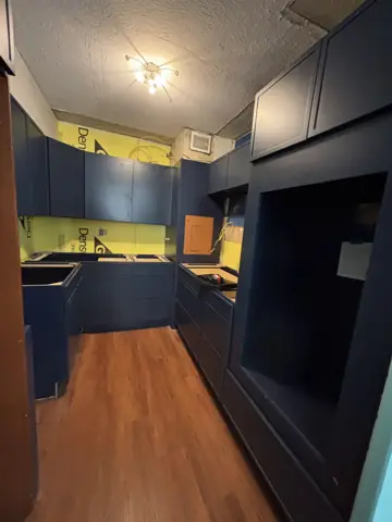 Navy and yellow kitchen remodel with wood floors