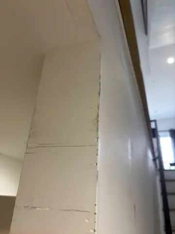 New drywall sheets hung and taped on a tall wall