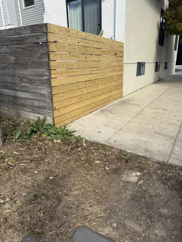 New horizontal wood privacy fence installed beside a home