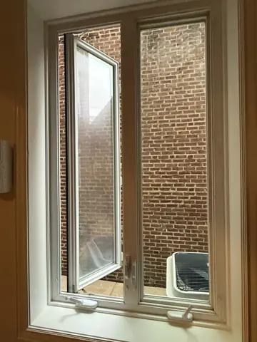 New window installed in a brick rowhome wall