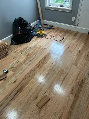 Newly refinished hardwood floor in an empty room