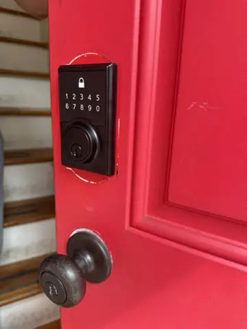Red front door with a new keypad smart lock and knob installed