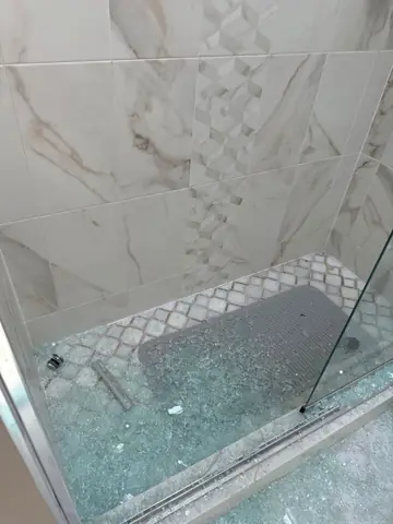 Tiled shower floor with marble-look walls
