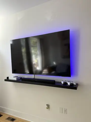 Wall-mounted TV with LED backlight and floating shelf