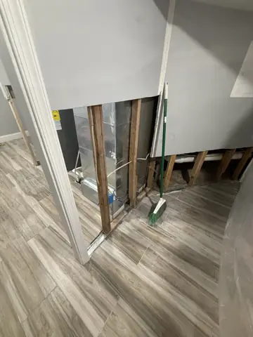 Wall opened to the studs and plumbing during a water-damage repair
